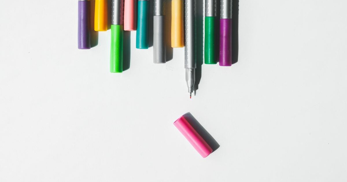 A series of colourful felt tipped pens, one with the cap off and pushed forward.